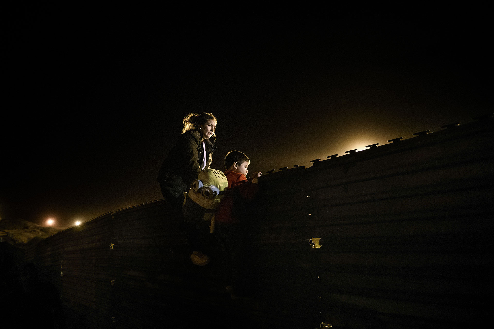 A Honduran mother and her son scale the wall to jump over to the U.S. from Tijuana on 26 December 2018.