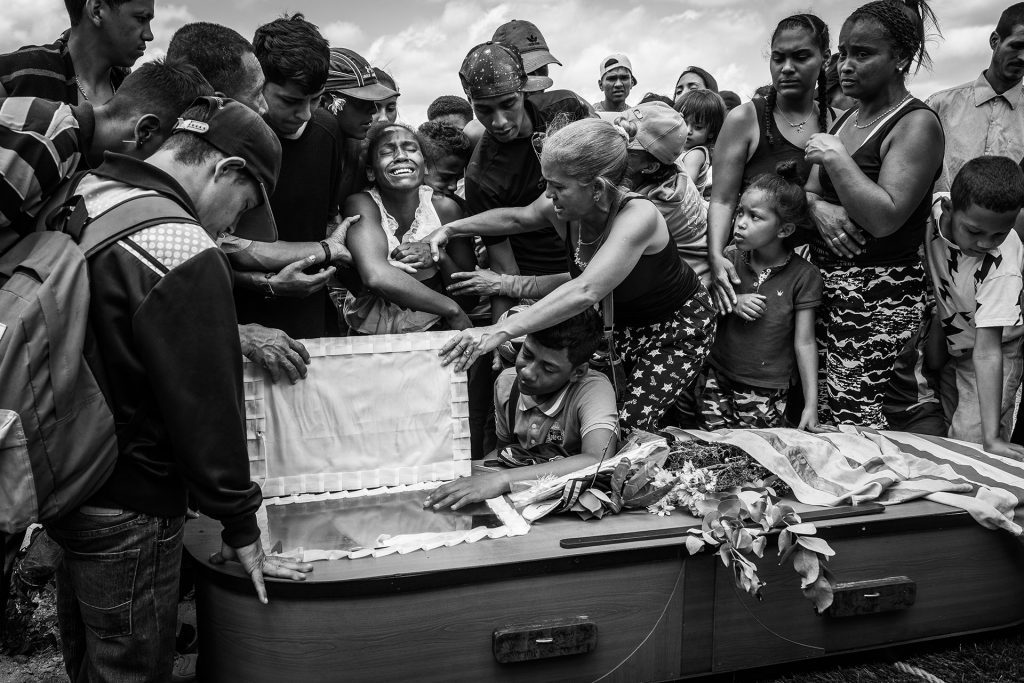 A woman cries at the funeral of her husband, Keiber Cubero, aged 25. As a father struggling to find food for his daughter, Keiber went out one night with others to rob a restaurant but were caught and killed by the police.