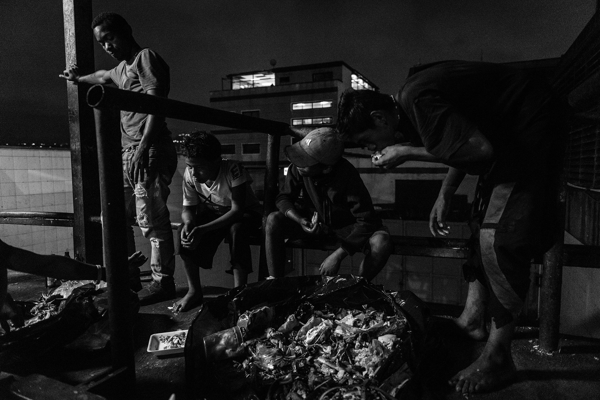 A group of children looks for food in the waste generated by a large shopping centre. According to Caritas, 53% of families have been forced to look for food from non-conventional sources, often understood as a euphemism for the rubbish bins.