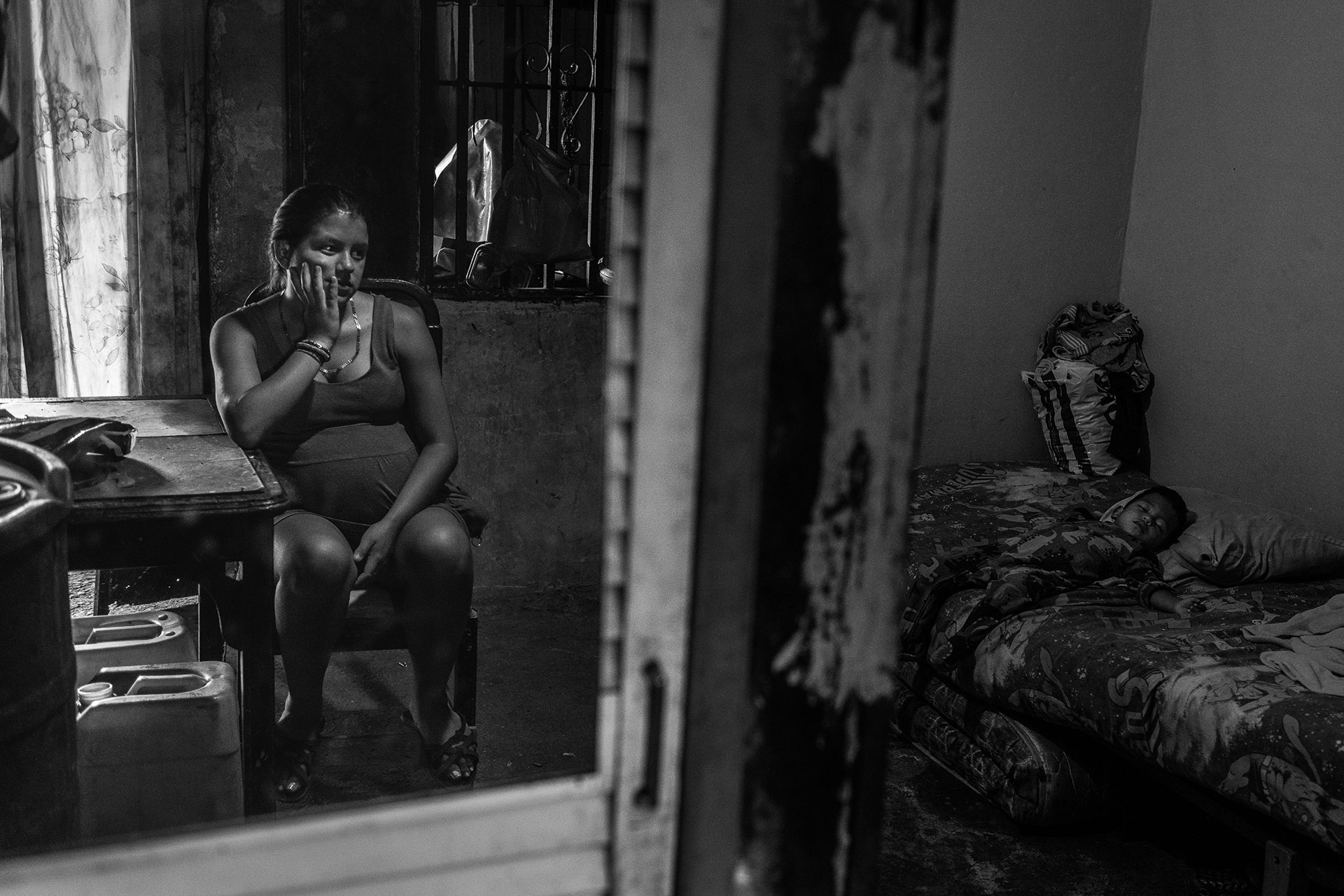 Roxana Gutiérrez, aged 19, looks after her son in her home in a poor neighbourhood of Caracas. Although both she and her husband Carlos, aged 20, have steady jobs, the crisis and shortages made it increasingly difficult to find food, which led Carlos to go out at night and steal motorbikes. He was captured by the police on his first attempt and is currently serving a sentence in jail. Roxana is pregnant with their second child.