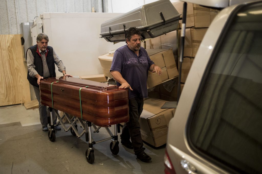 Martín Zamora and a colleague push the coffin carrying the corpse of Zohra Sarrouj at the Southern Funeral Assistance premises in Algeciras, Spain.