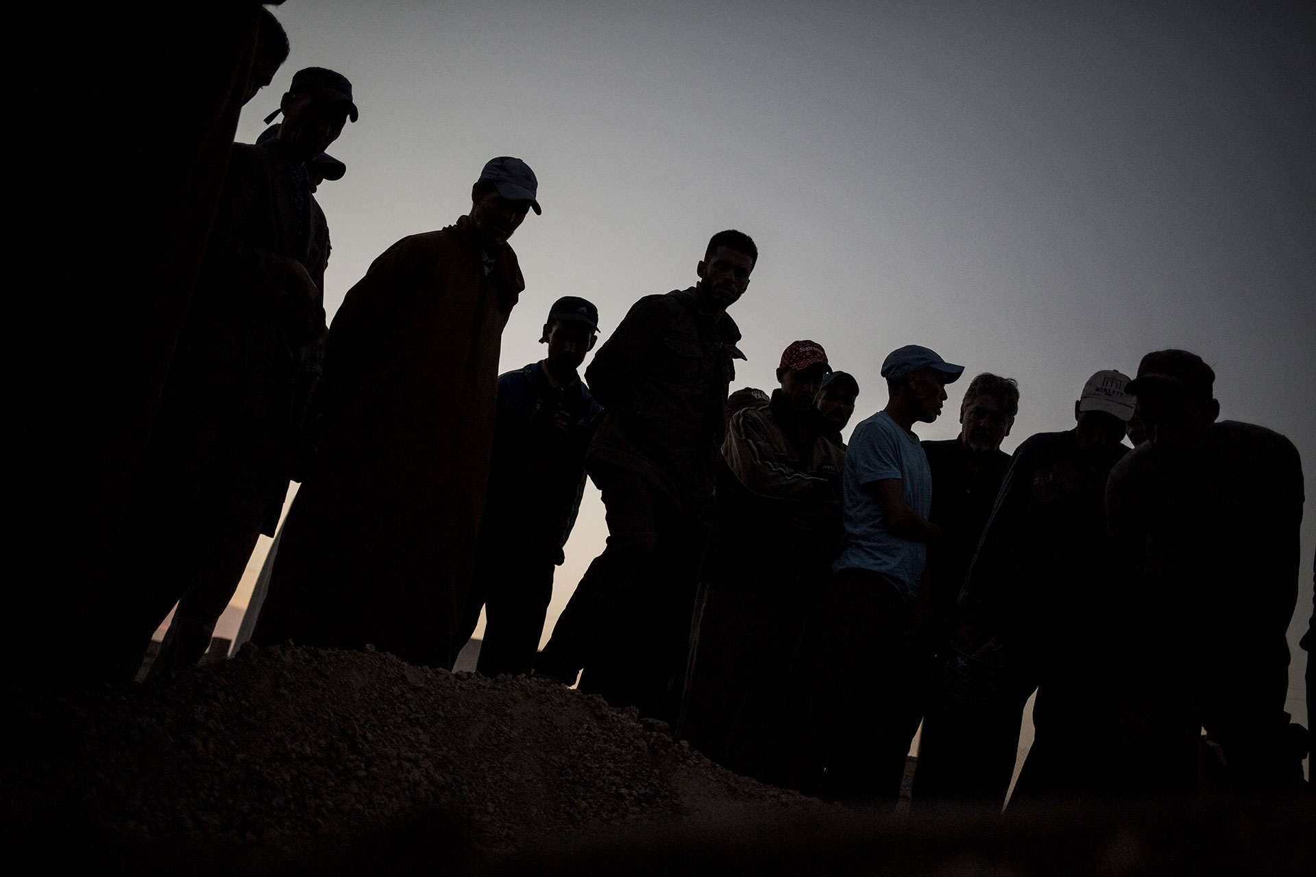 People gather around the grave at Zohra Sarrouj’s burial.