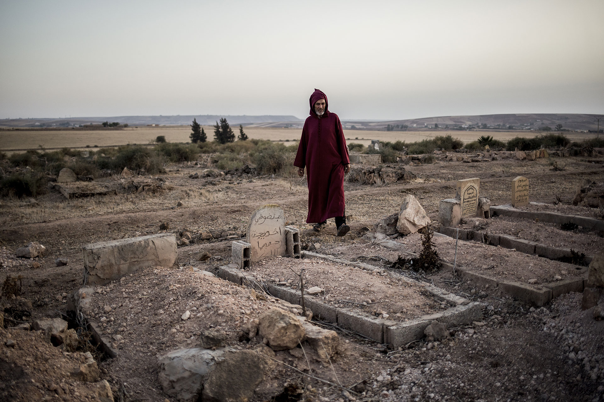 A man stands between tombs moments before the burial.