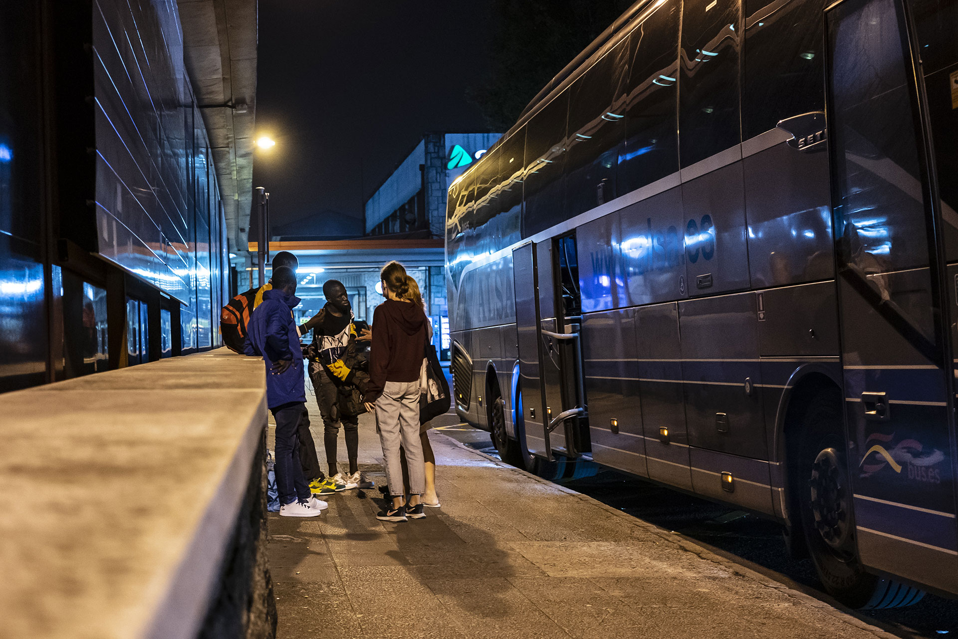 Miembros de Irungo Harrera Sarea hablan con un joven que acaba de llegar a la estación de autobuses de Irún, 17 de Septiembre de 2019.