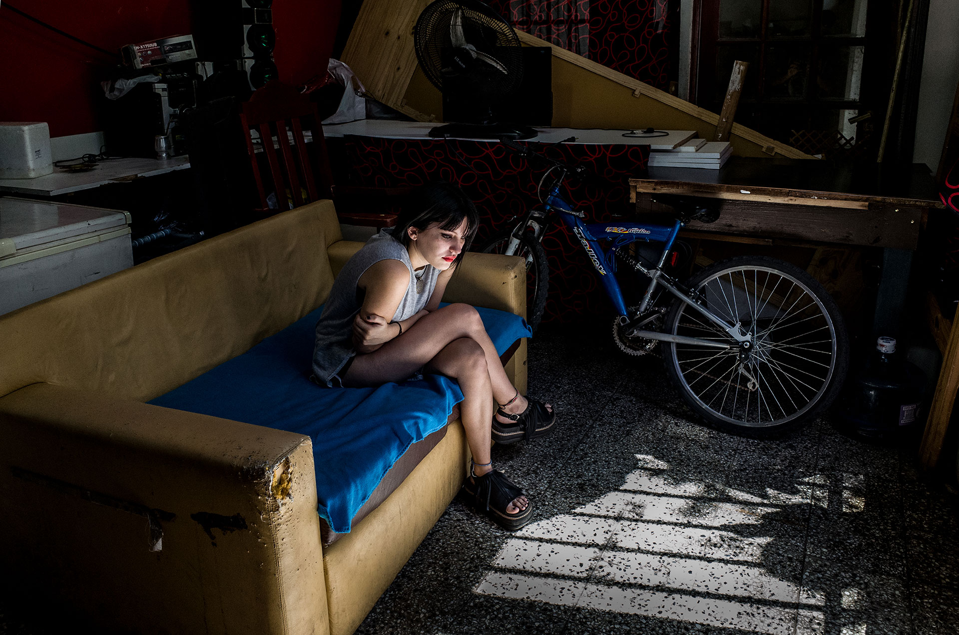Belén Torres, 20 years, seated in the garage of her family house. She was victim of the “anesthetist” Gerardo Biliris, nicknamed for his profession and his way of torturing his victims. She was founded in a lake of blood. The Police discovered that he abused of many girls using mix of drugs and sedatives.