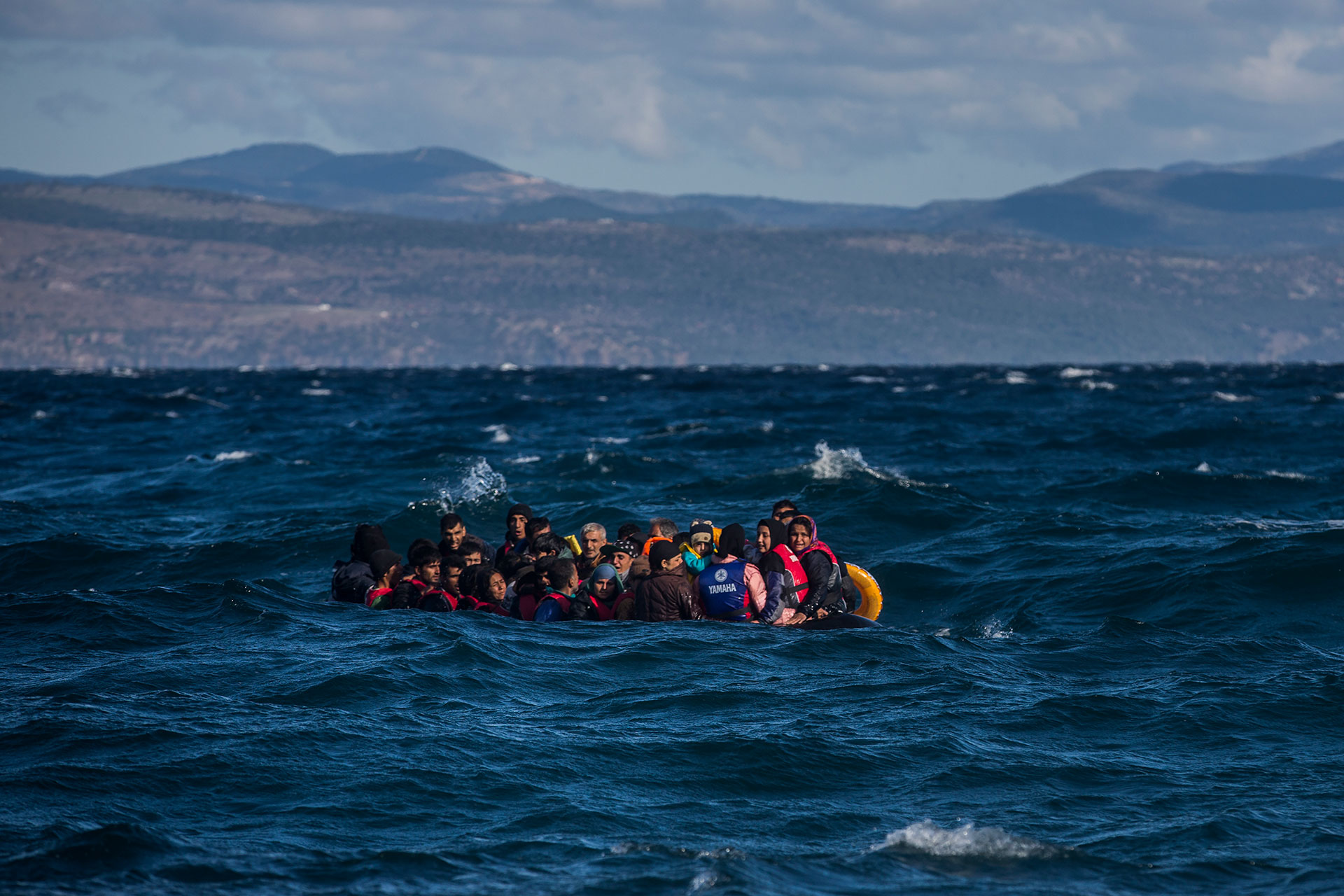 Scores of Afghan refugees approach the coasts of the Greek island of Lesbos on board an unstable plastic boat which is about to sink.
