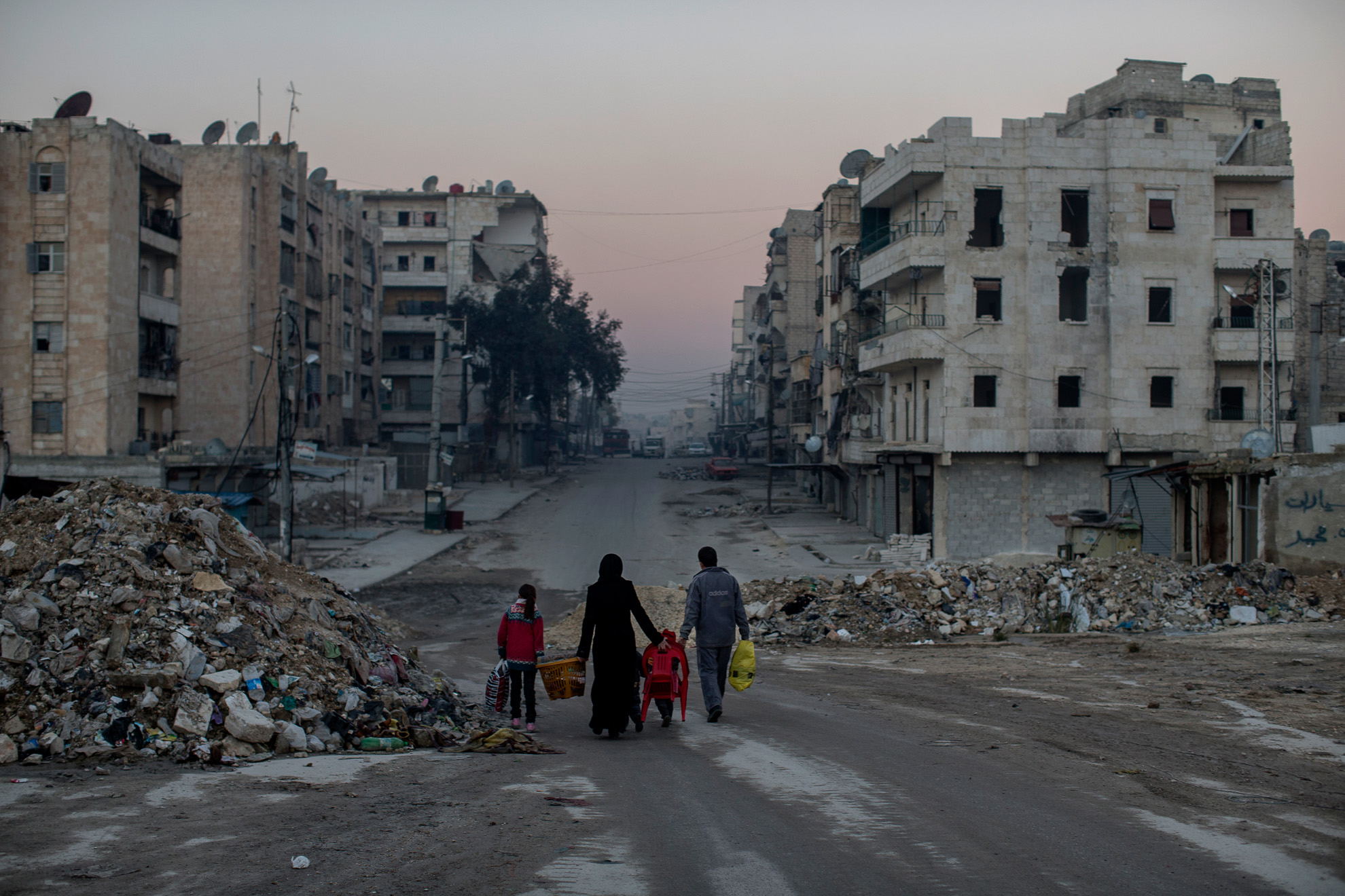 Aleppo, Syria. 2013-01-15. A family walks on empty streets of Aleppo. Trying to live a life in the war torn city.