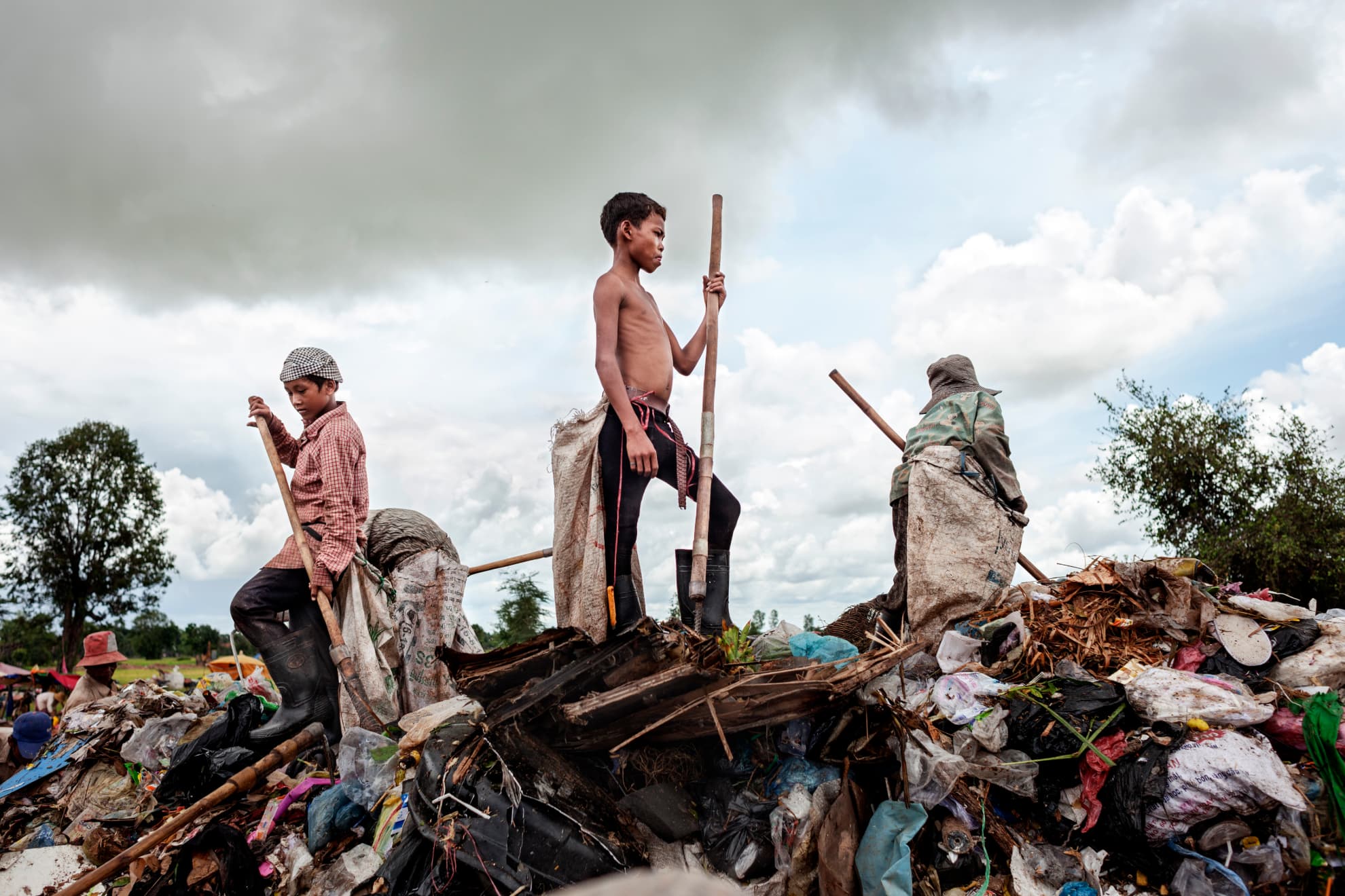 Kon Mai, aged 15, stands atop a mountain of rubbish. He began to work there at the age of 12 and had to leave school because his parents, also work in the rubbish dump, conti-nuously needed to go from one place to another to seek work. Kon Mai has four siblings, all minors. There are problems of domestic violence at home and he wants to leave as soon as he can. In the future, he plans to work in construction.