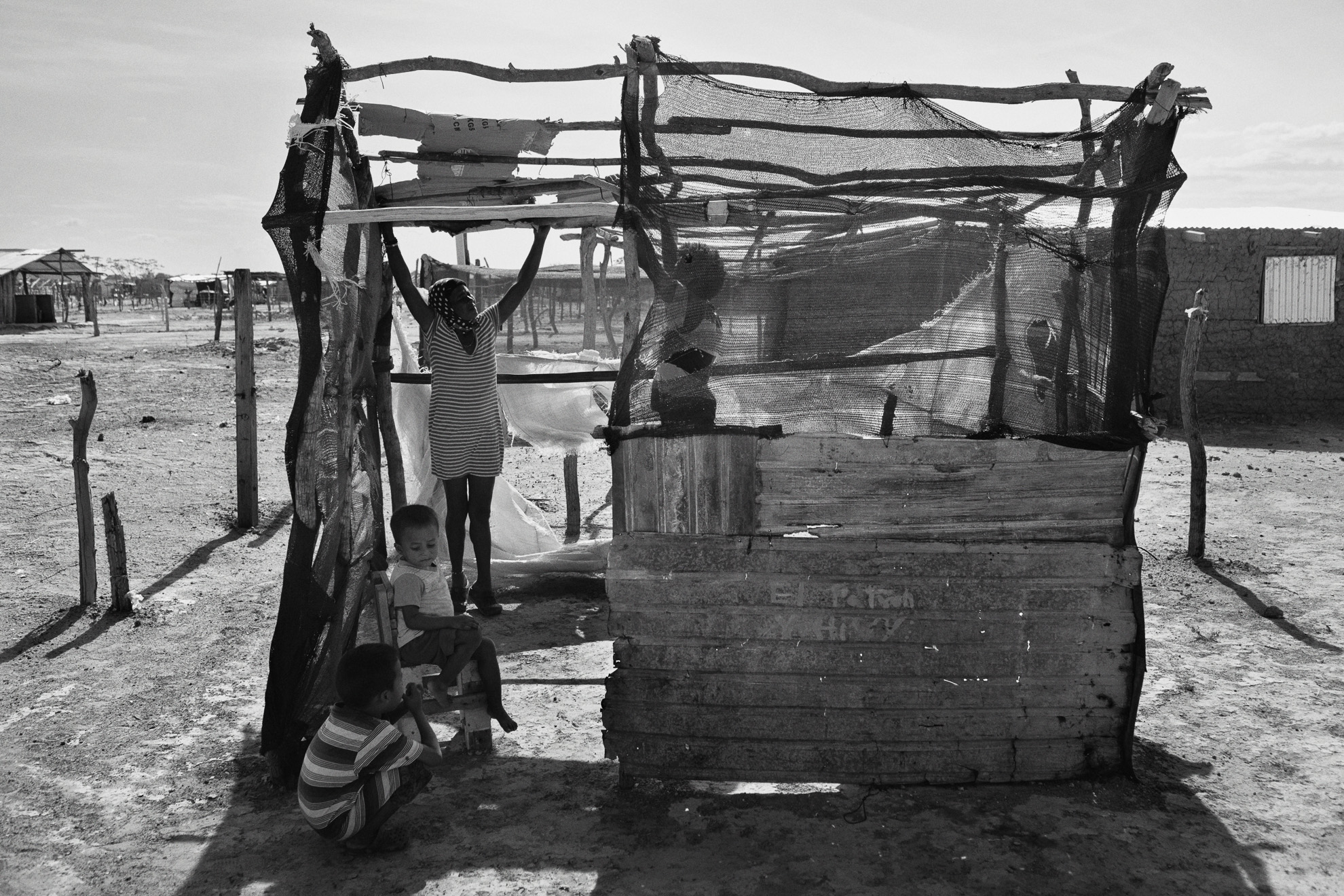 Una mujer está construyendo una choza en el desierto de La Guajira. Alrededor de 10 mil migrantes viven desde hace 2 años en una ciudad de tiendas de campaña en las afueras de Uribia, un pueblo indígena. Sin acceso a agua corriente y saneamiento, la gente está más expuesta a las enfermedades.