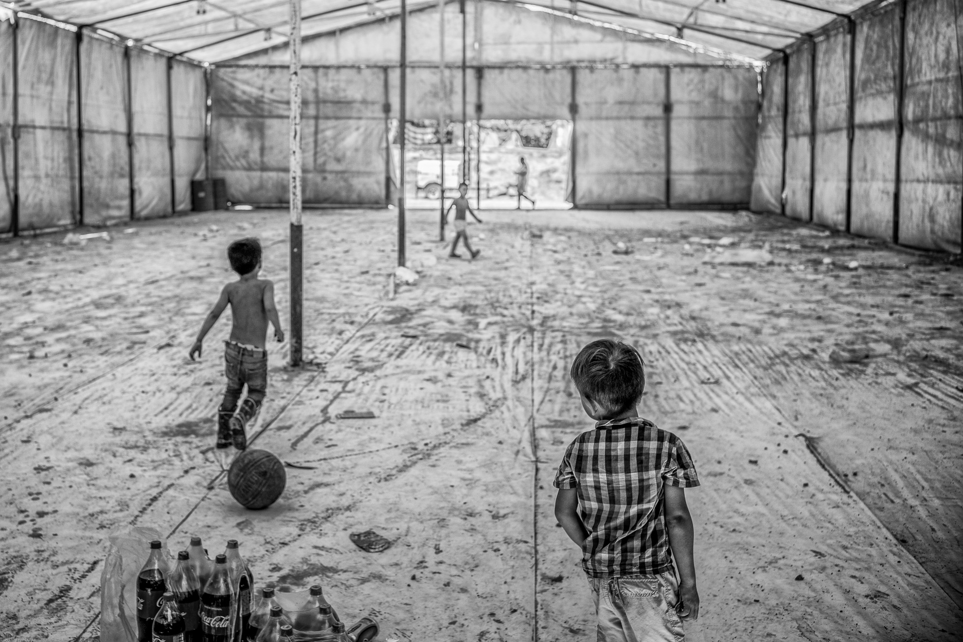 Niños salvadoreños juegan dentro de una tienda de campaña que servía de comedor colectivo en el campamento de solicitantes de asilo en Matamoros, México.