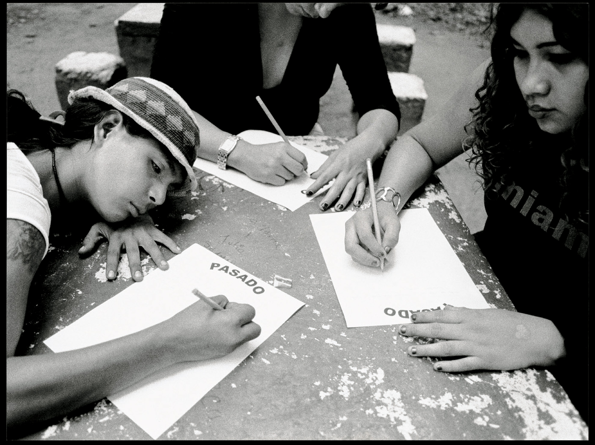 Raquel, Jessica and Kamila (from left to right) write about their past. The photograph shows the expression of these girls as they face their memories, all that they have had to endure. These were moments of dense, sad silence, but they also served to empty their pain onto these sheets of paper entitled "Past". Kamila's blank stare as she looked back over her life is evidence of her pain. Kamila was a five-year-old boy when he was raped and only a teenager when he started prostituting himself by adopting a new female identity. He has had to fight against the prejudices of a society that does not accept gays, let alone transvestites. Poverty also led her to crime and violence. Under her clothes are hidden three bullet wounds, which almost ended her life. Today, he prostitutes herself in the same place where Jessica does.