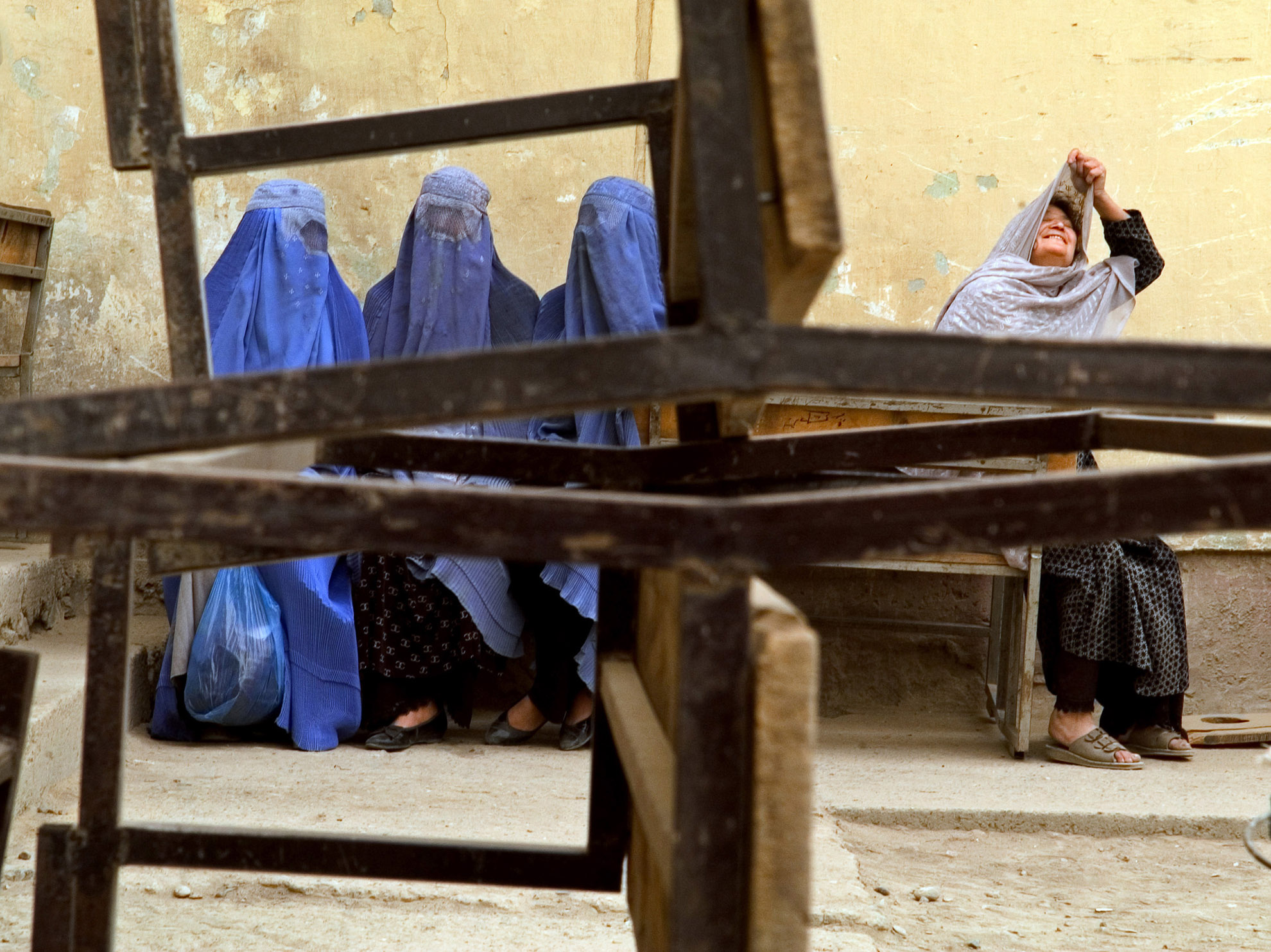 This image was taken on election day in Kabul, October 9, 2004 - the first time women were given the right to vote in a democratic election in Afghanistan. Despite inflated numbers and a fraudulent electoral process, women in Kabul - at least some of them - voted of their own free will. In rural regions, it was more likely the case that women (most of whom are illiterate) voted for whomever their husbands, fathers and brothers told them to vote for.This image was taken just after four women voted at a high school in Kabul.