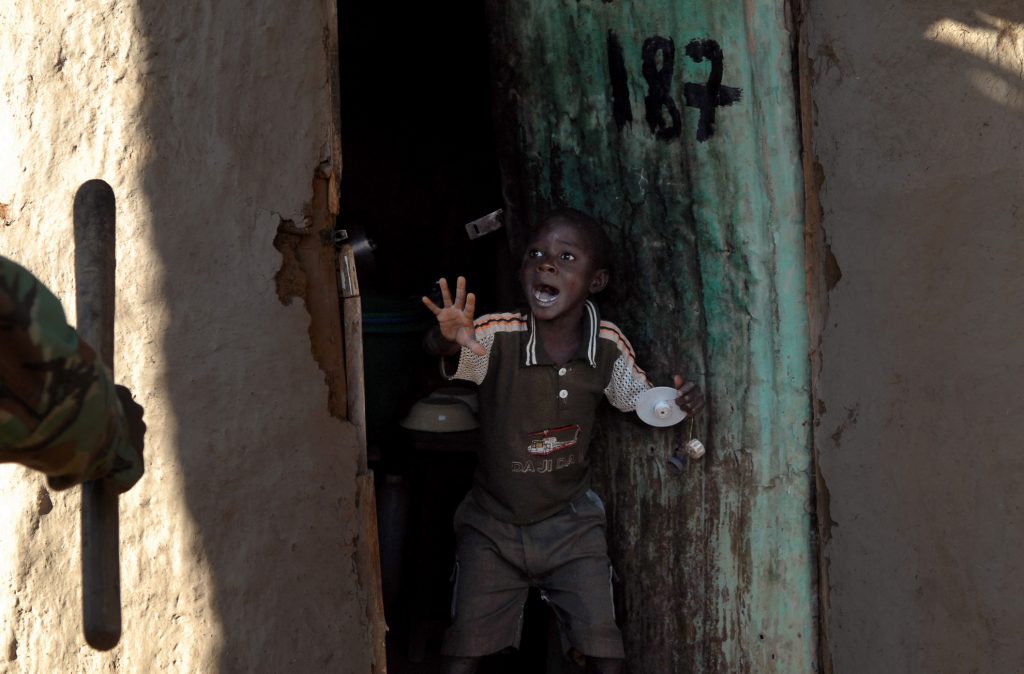 Monday Lawiland, de 7 años de edad, grita después de que la Policía keniana haya derribado de una patada la puerta de su casa en el barrio de Kibera, Nairobi, el 17 de enero de 2008.