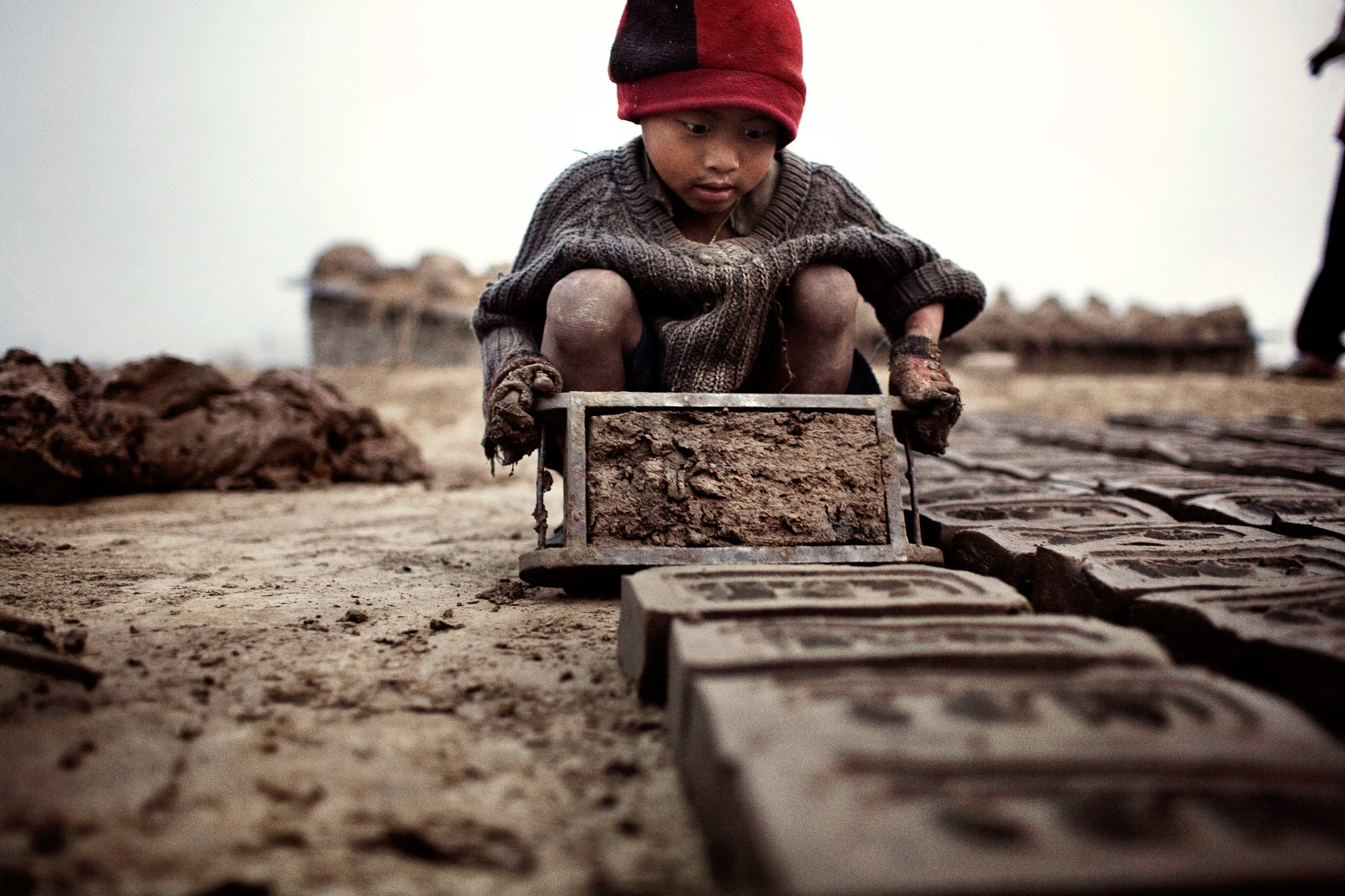 7 a.m. and Yadhu, aged 4, is already making bricks. His working day will end around 6 pm. From the age of 4, these children are forced to go out to work to bring home money for their families.