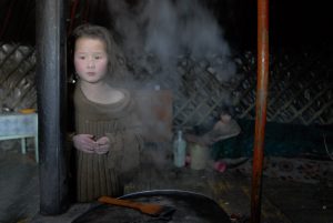 Uyanga, 12 años, se calienta cerca de la cocina en la ger (tienda) de su familia proporcionada por Save the Children en Ulán Bator, Mongolia, el 5 marzo de 2007. Uyanga vive con su madre alcohólica y desempleada y sus siete hermanos, que salen a trabajar a diario en busca de algo para comer. La pobreza infantil es un problema grave en Mongolia, que deja en la calle muchos niños y niñas necesitados en situación de gran vulnerabilidad.