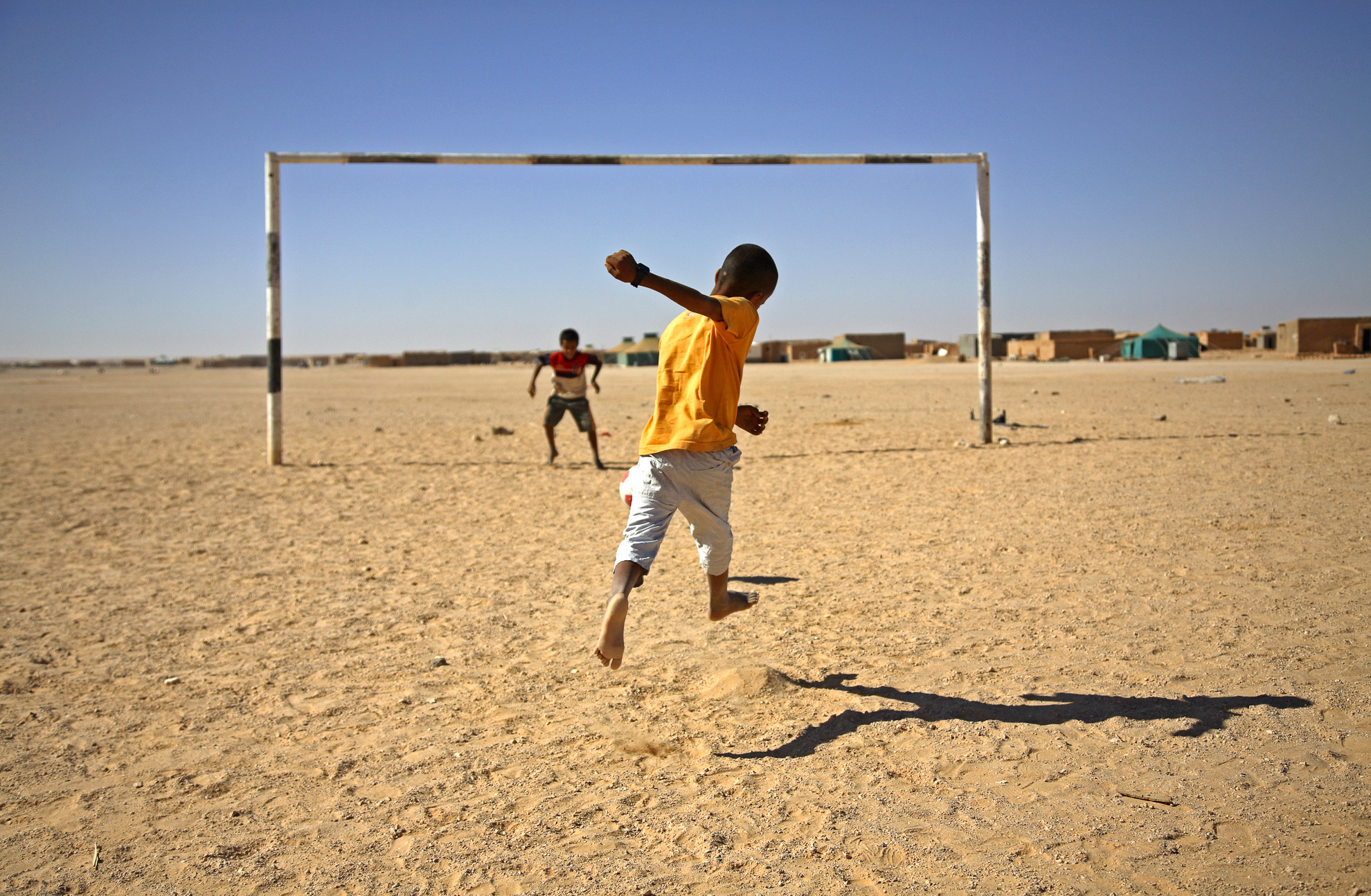 Niños jugando al fútbol bajo un sol abrasador, en el campo de refugiados saharauis de Smara. El fútbol es su principal diversión.