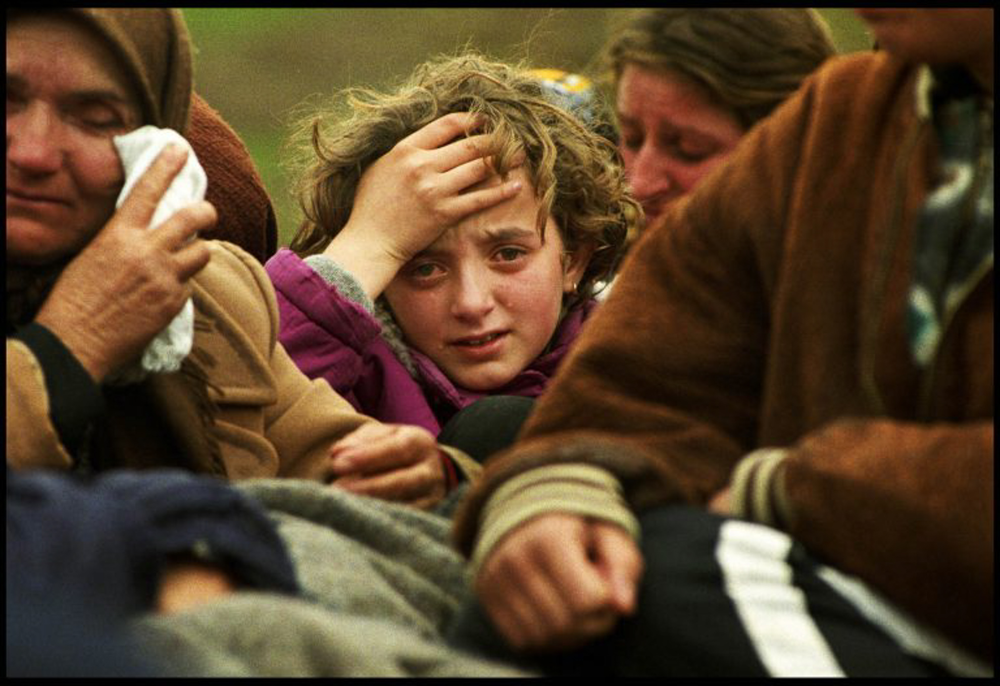 Una familia de personas refugiadas que huyen desde hace varios días de la represión serbia, llegan a territorio albanés en el remolque destartalado de un tractor, su única pertenencia, y rompen en llanto al atravesar el paso fronterizo de Morina, que separa Albania de su tierra, Kosovo. I, abril-mayo 1999