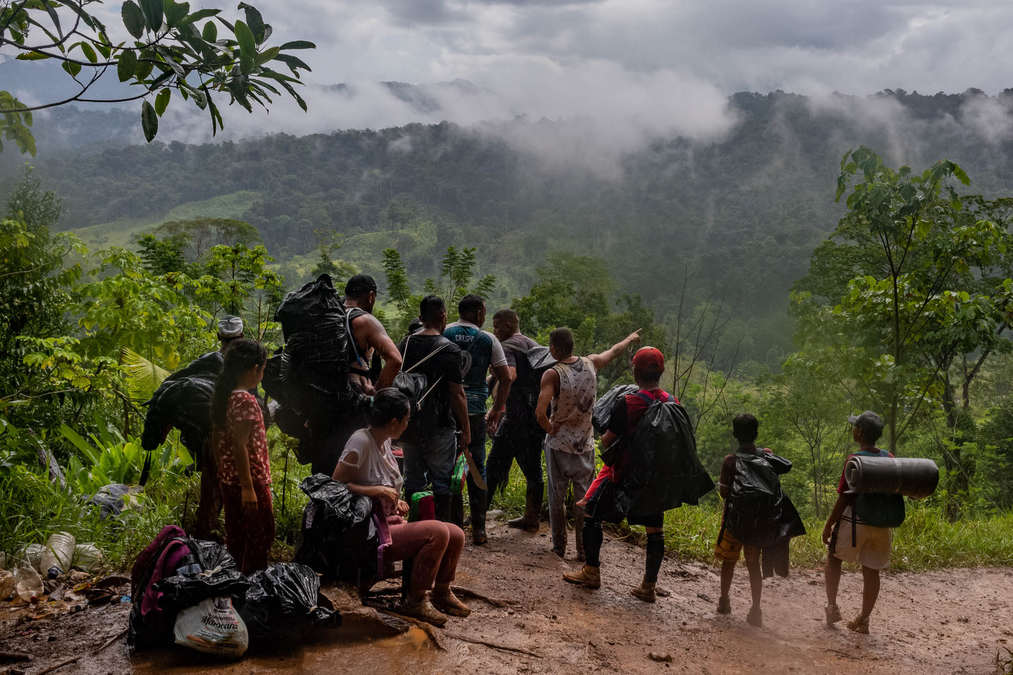 A group of migrants stops on a hill while crossing the Darien Gap between Colombia and Panama. In dozens of interviews over several days traveling the route, it became clear that a combination of desperation, the enduring lure of the American dream, and misleading social media posts are creating a humanitarian crisis the likes of which the Darien has never seen before. September 2022.