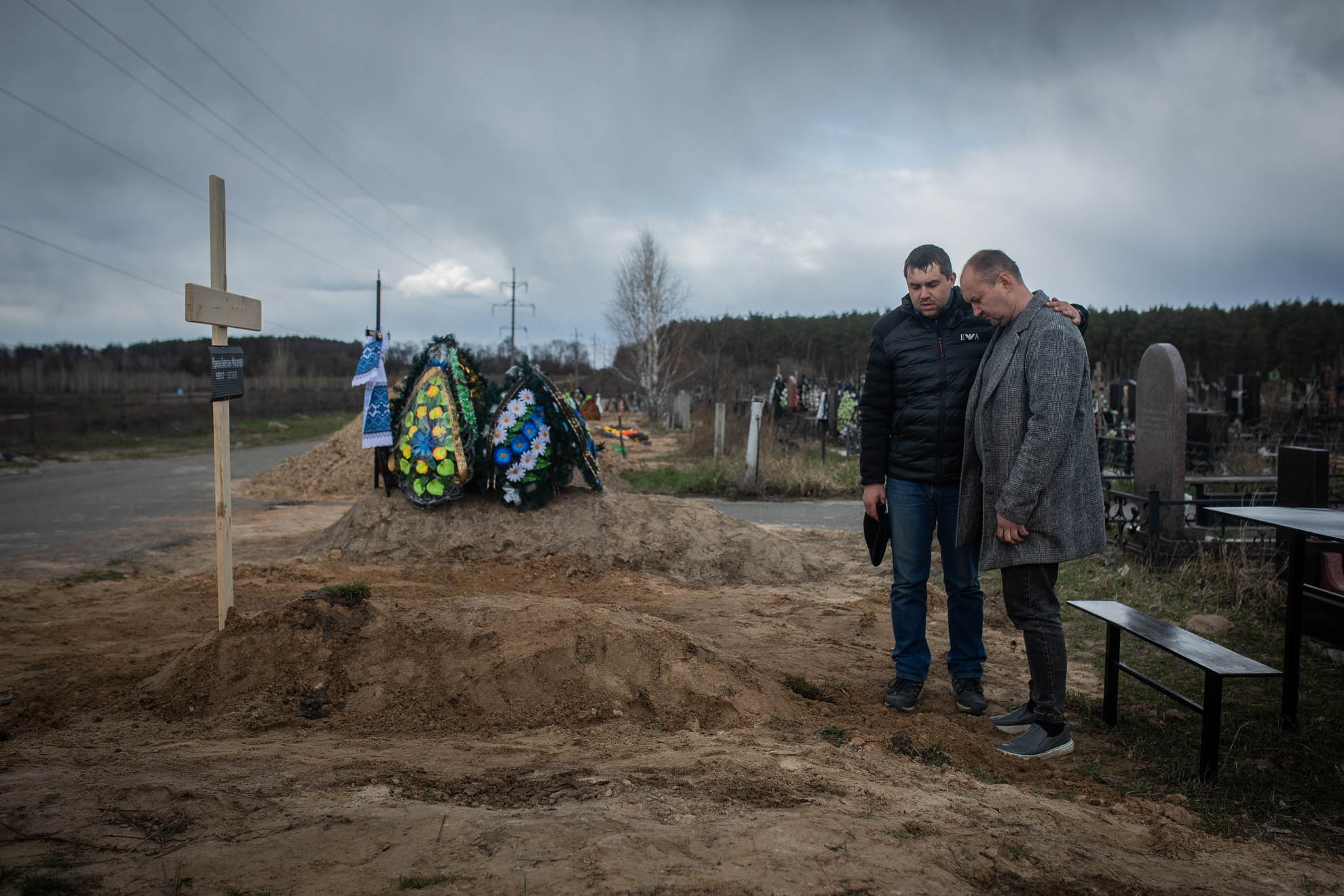 The burial of 82-year-old Valentina on April 12, 2022. The woman died during the Russian occupation in the nursing home where she lived. After the withdrawal of the troops, the bodies of six of its residents, including Valentina's, were found in the facility. In front of her grave is her son, Anatoliy. He said that at all times the nursing home workers tried to take care of the elderly. But due to the lack of electricity, water, gas, and medicines, and taking into account the precarious health of these people, they gradually died.