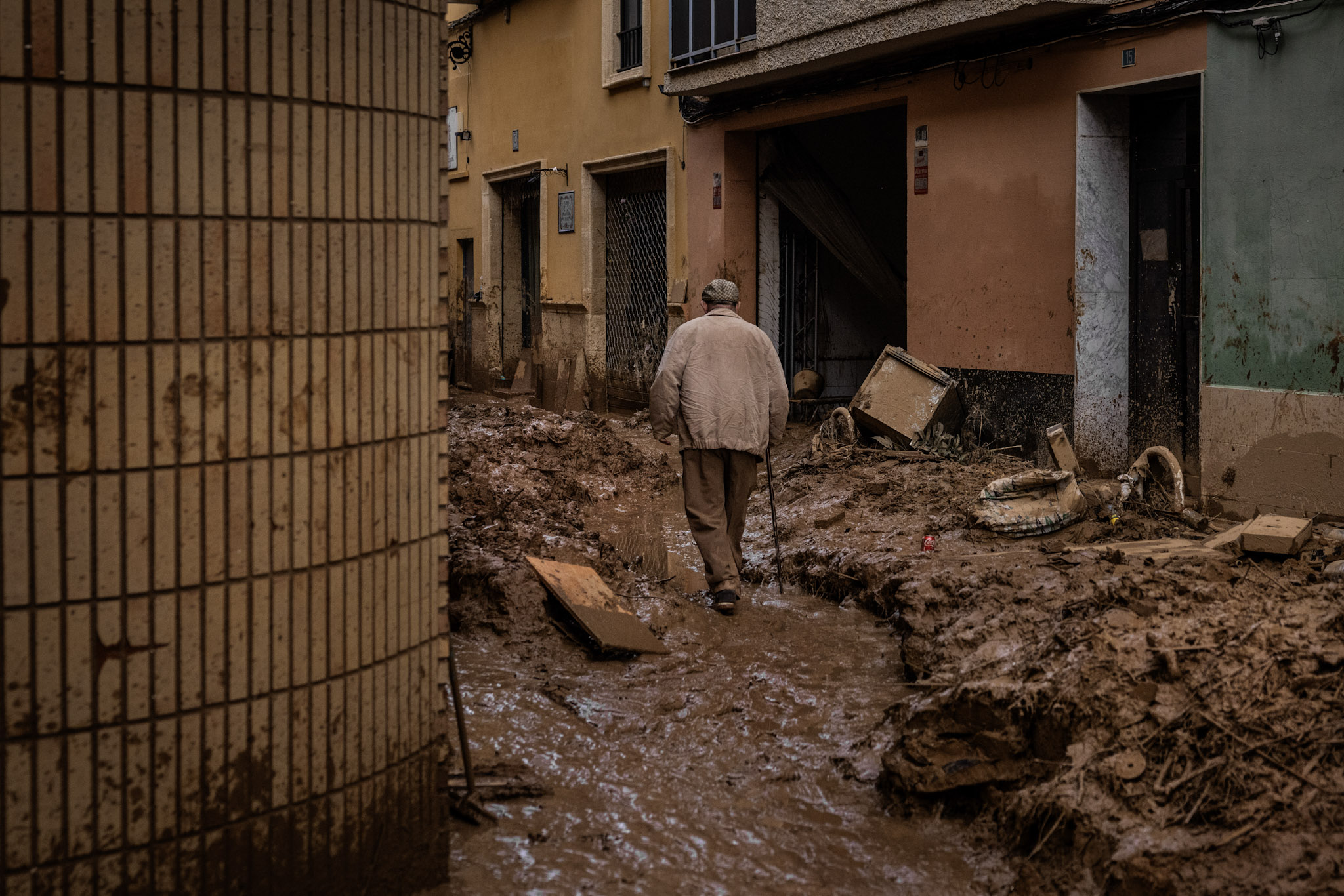 Un hombre camina sobre el barro en una céntrica calle de Paiporta. El casco antiguo de este municipio fue una de las zonas más afectadas por las inundaciones debido a su proximidad al barranco de Poyo, que canalizó la riada, y por la abundancia de casas de una sola planta, donde viven muchas personas mayores que no tuvieron forma de escapar cuando comenzó a subir el nivel del agua.